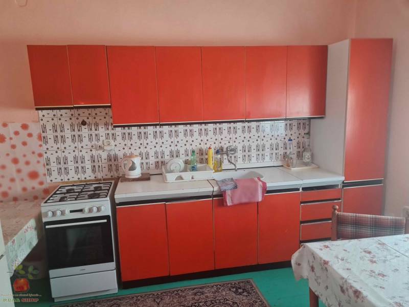 Rodinný dom s retro kuchynskou linkou v červených tónoch a kachličkovým obkladom.