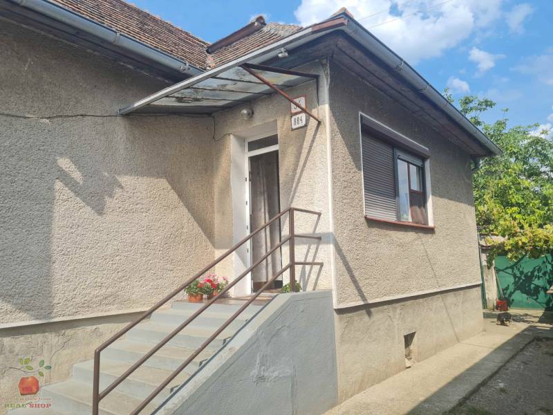 Rodinný dom v Komjaticiach má schody so zábradlím, vstupné dvere a okno s roletou.