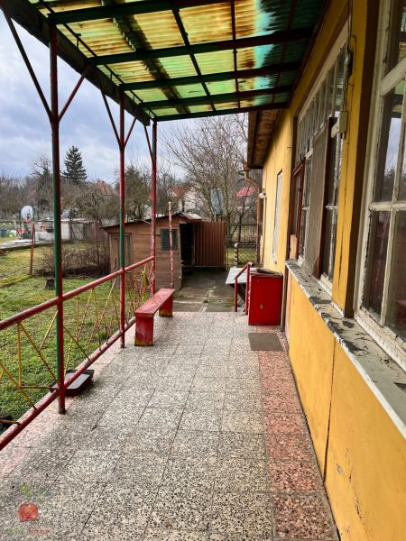 Terasa s lavičkami a dlažbou pri rodinnom dome v Komjaticiach, výhľad do záhrady.